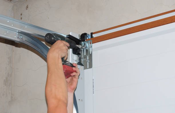 Technician repairing damaged garage door tracks for improved movement and safety.