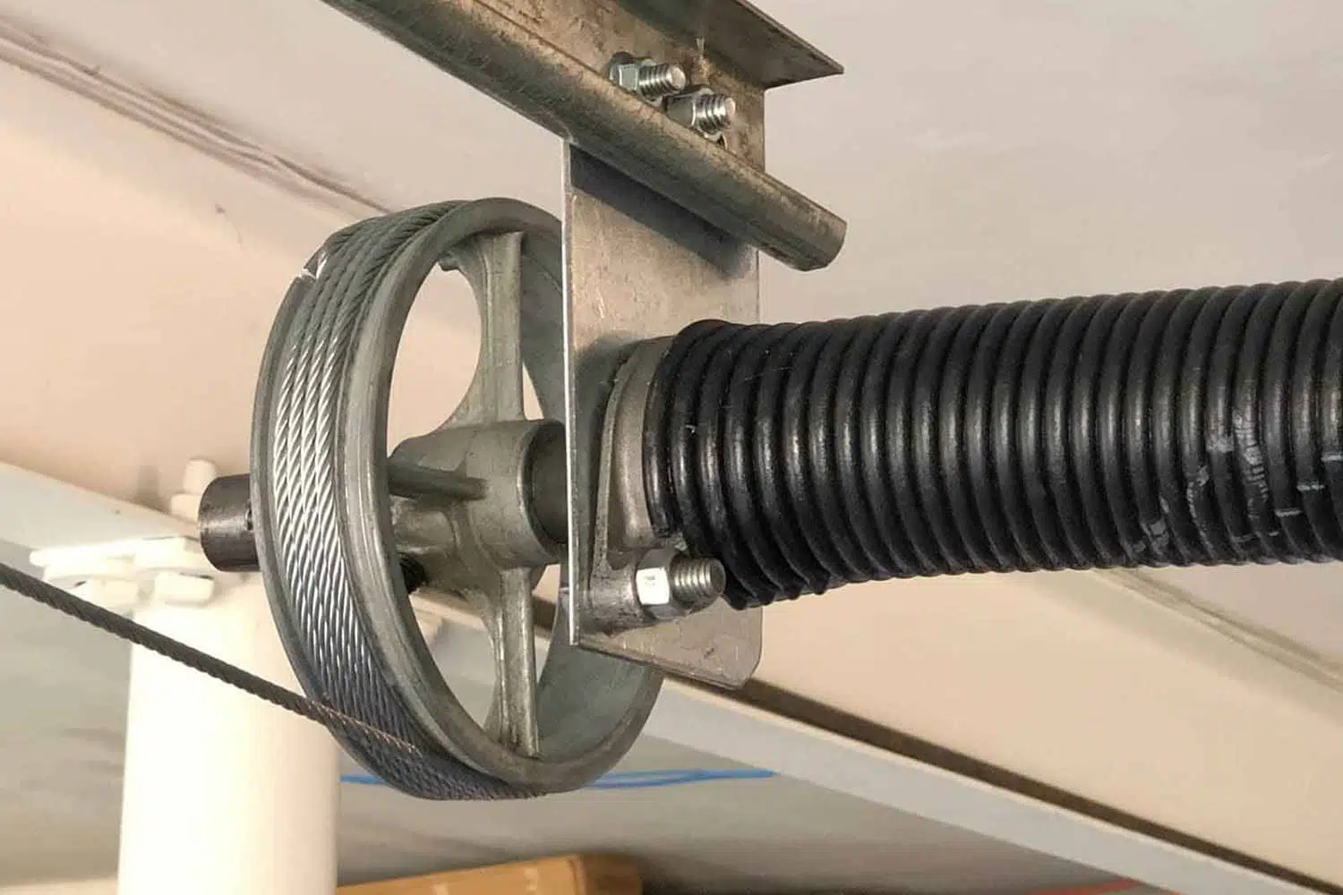 a metal pulley with a black coiled tube