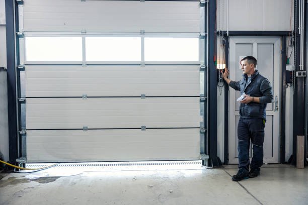 Technician holding a universal remote control during garage door remote control programming.