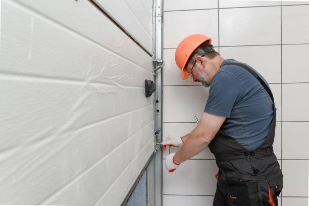 Technician adjusting an off-track garage door during a repair service.