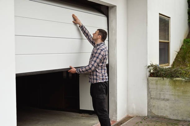 Technician repairing a broken garage door spring during a garage door repair service.