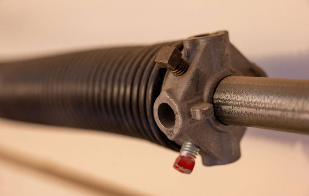 Technician installing a new torsion spring on a garage door