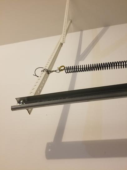 Close-up of garage door extension springs being adjusted to correct door balance.