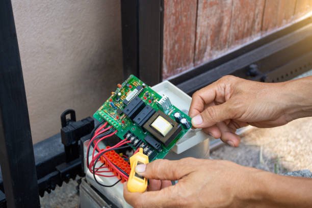 Technician repairing a malfunctioning garage door keypad.