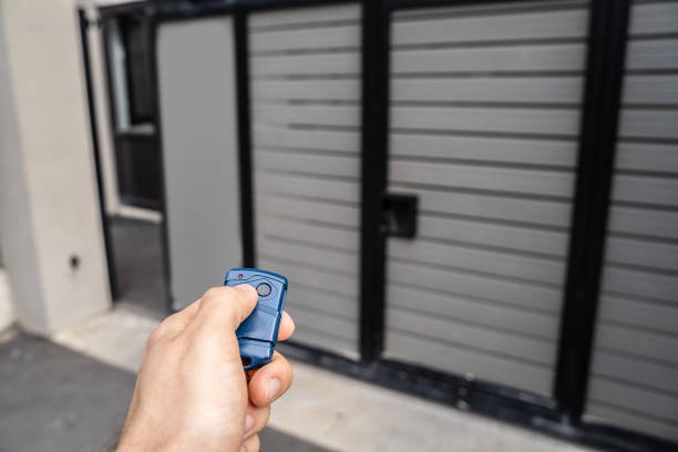 Technician reprogramming a garage door remote control to fix operational issues.