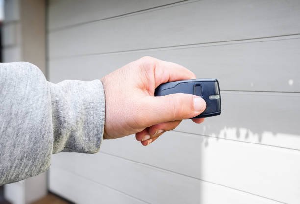 Close-up of a garage door remote being synchronized with a new opener system.